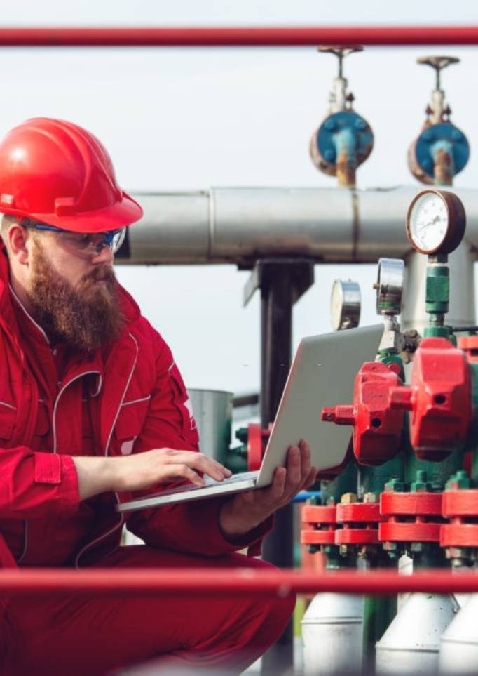 Industrial Worker Dressed In Red Uniform Working On Gauges
