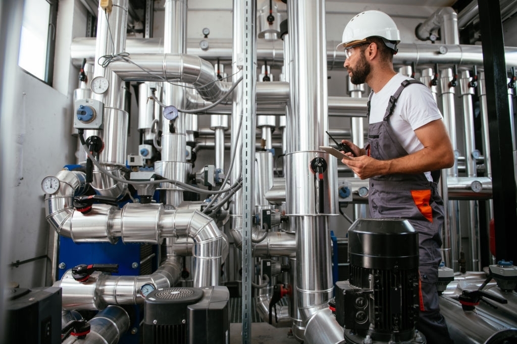 Mechanical Worker With Clipboard Inspecting Large Pipe Structure