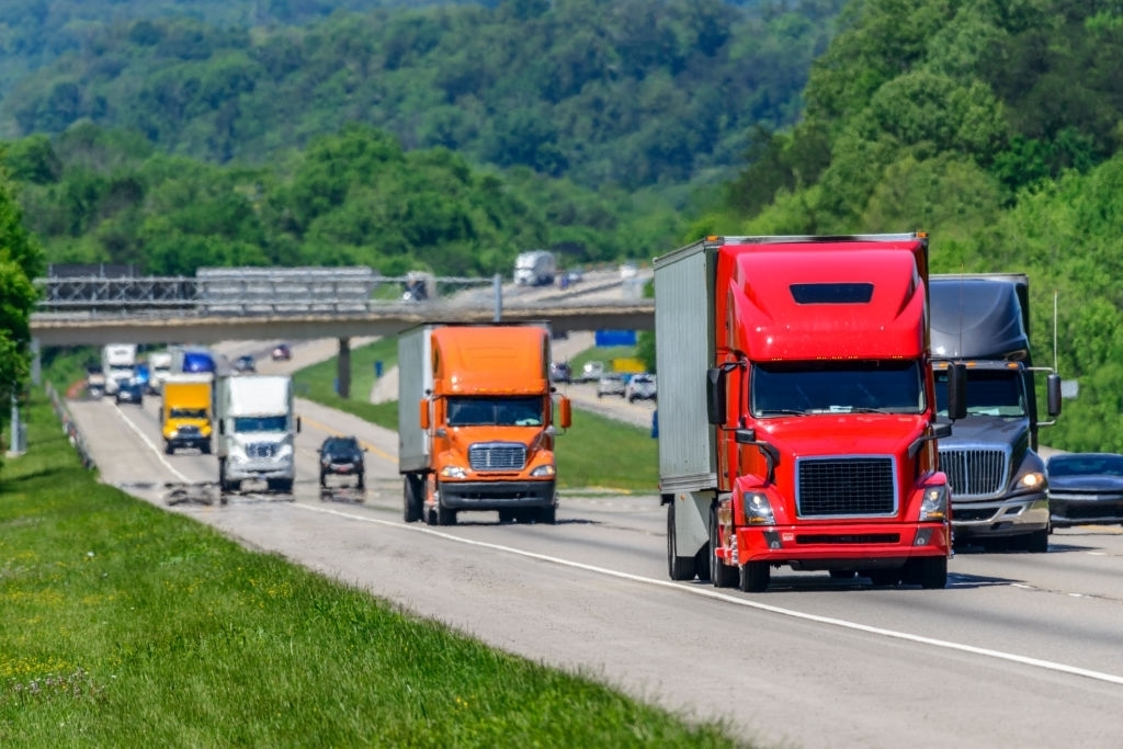 Several 18 Wheeler Trucks Driving Down Highway Several 18 Wheeler Trucks Driving Down Highway