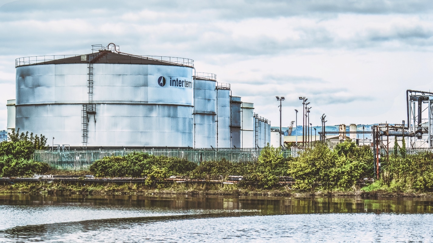 Large Silos In A Row Next To A River