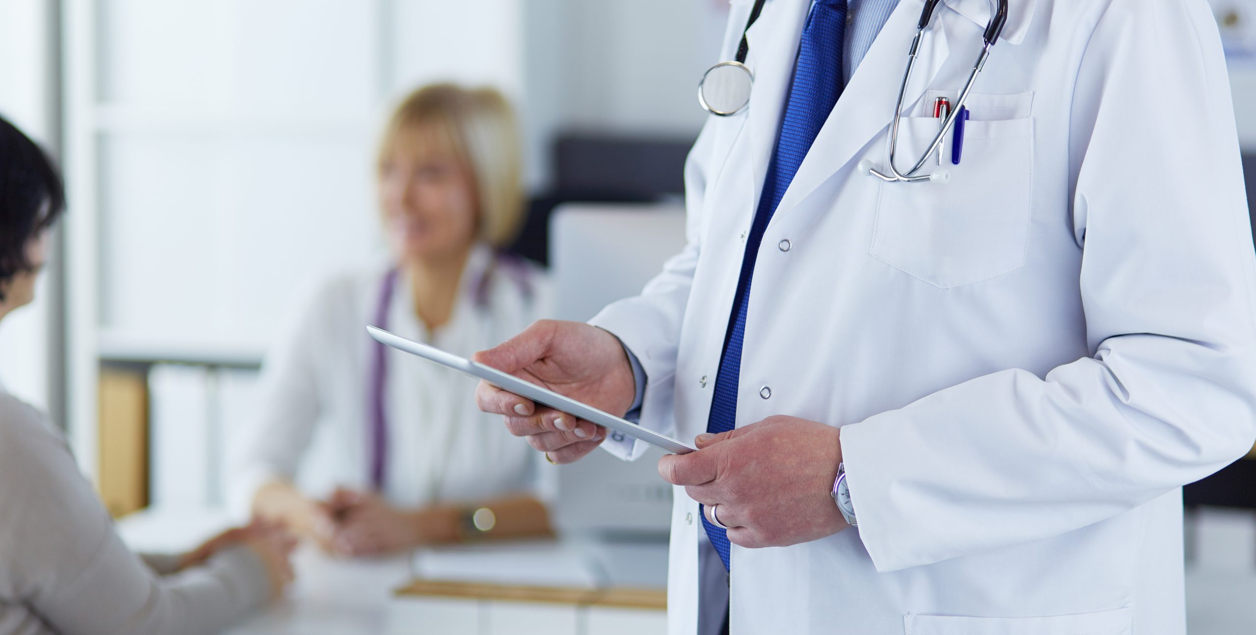 Portrait,Of,Senior,Doctor,In,Office,Sitting,At,The,Desk