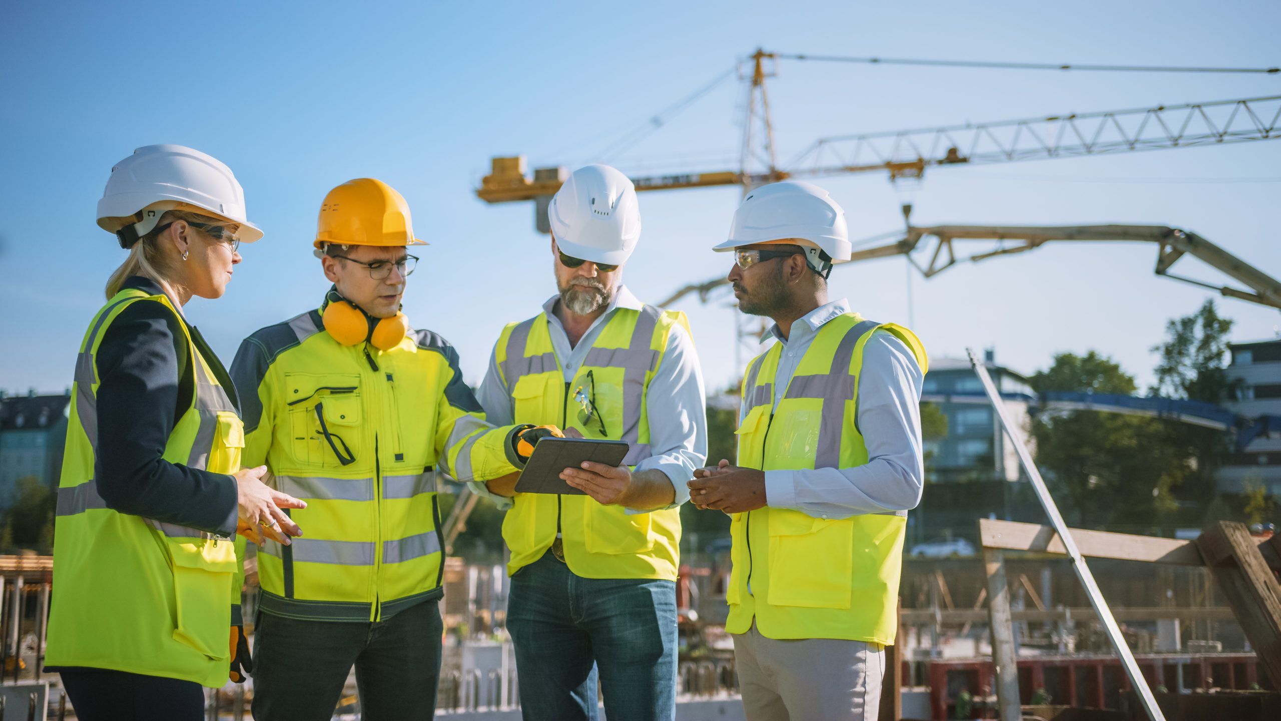 Diverse,Team,Of,Specialists,Use,Tablet,Computer,On,Construction,Site. Diverse,Team,Of,Specialists,Use,Tablet,Computer,On,Construction,Site.