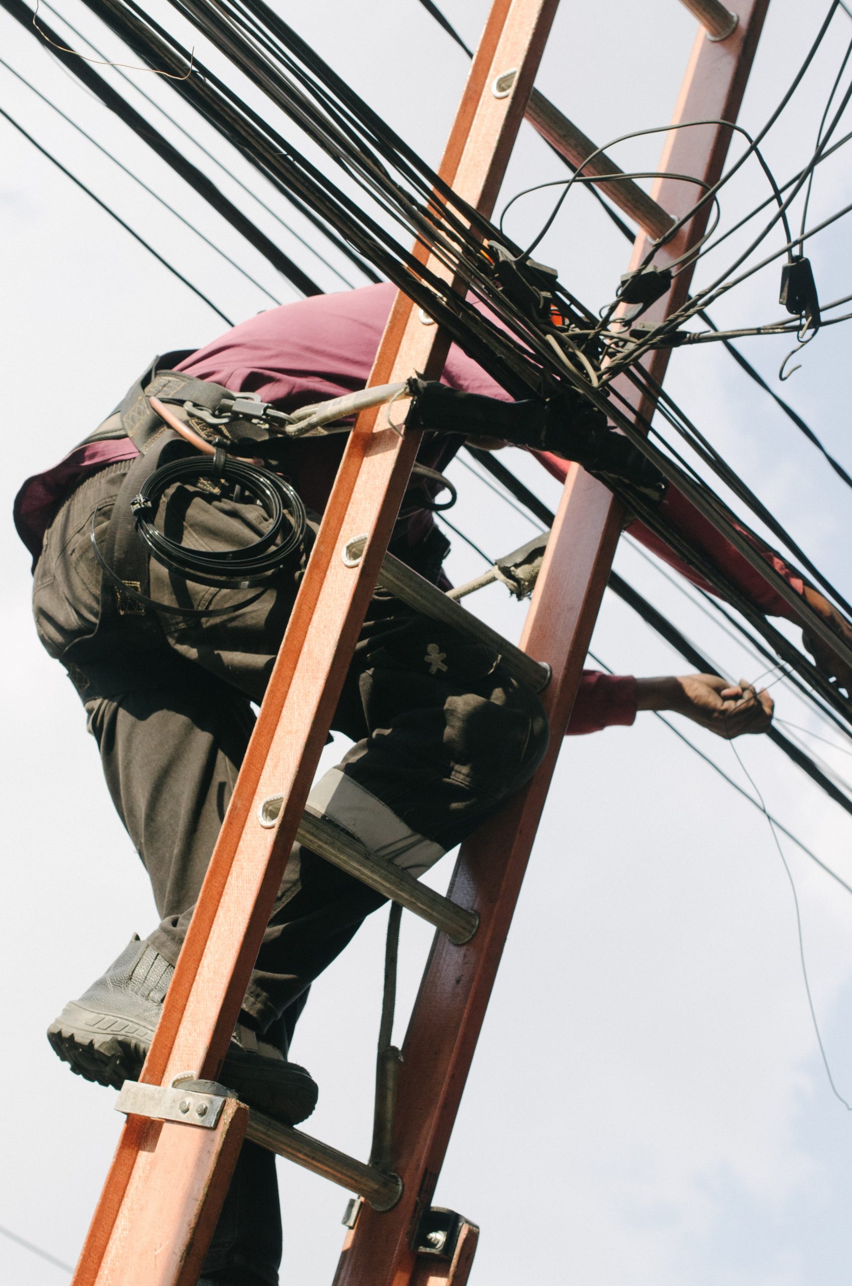 Man On Extension Ladder Working On Electrical Lines Man On Extension Ladder Working On Electrical Lines