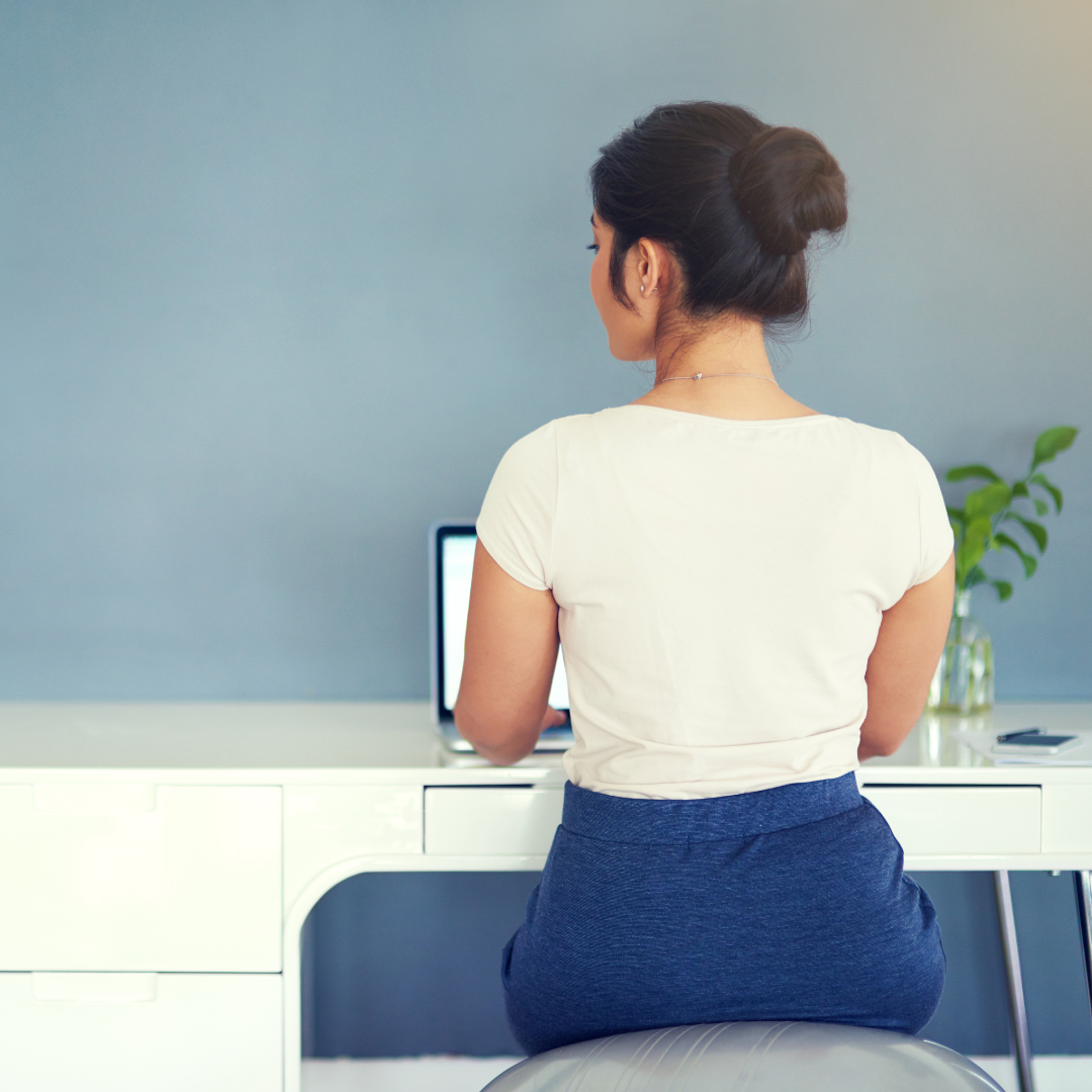 Businesswoman Sitting on Exercise Ball at Desk with Good Posture