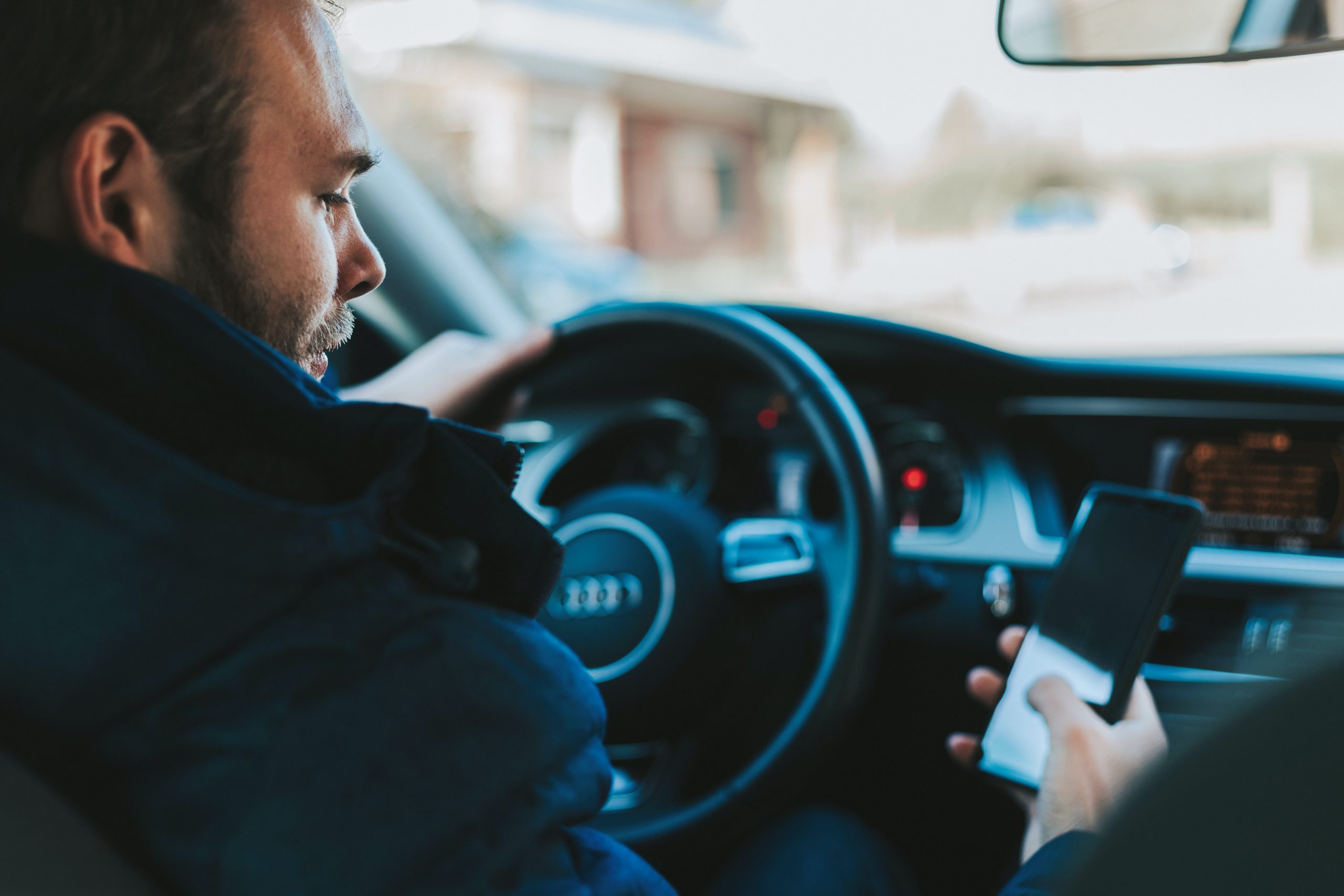 Man Driving Audi Distracted by Looking at Phone Man Driving Audi Distracted by Looking at Phone