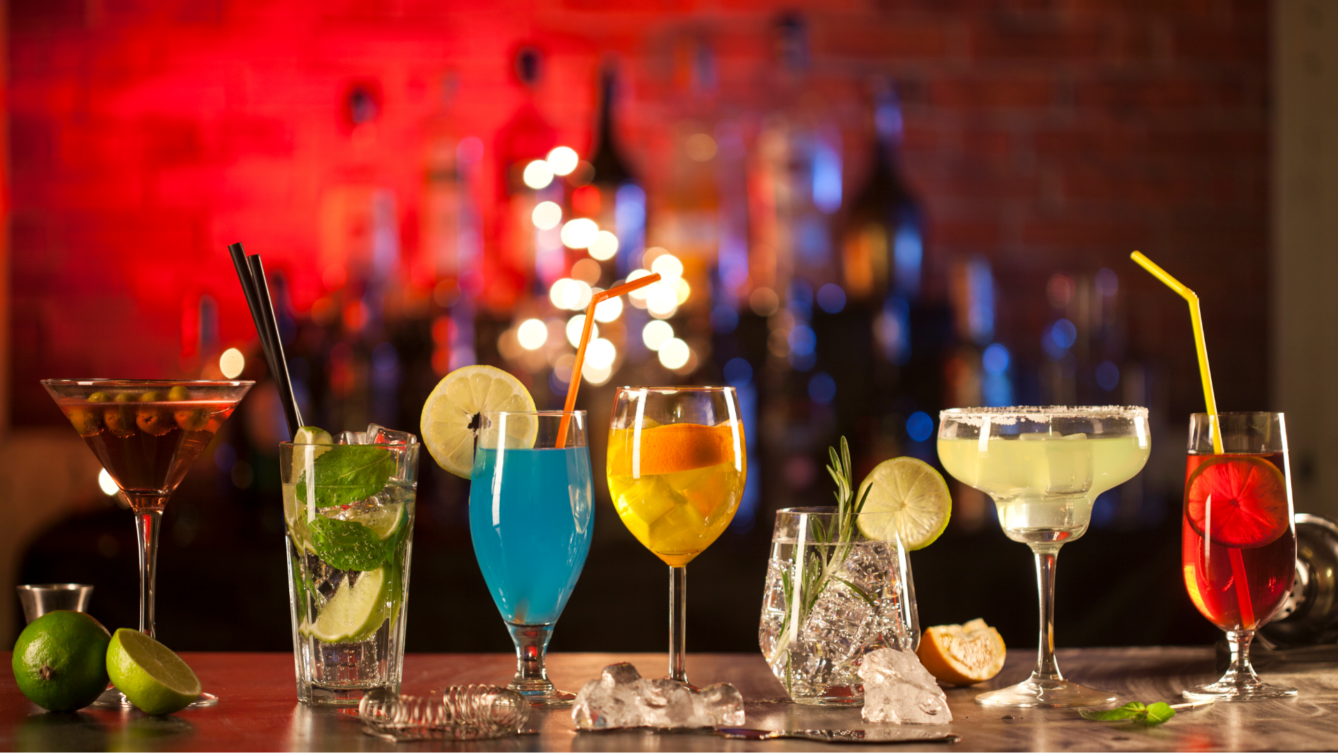 Line of Colorful Cocktails in Various Sized Glasses on Bar