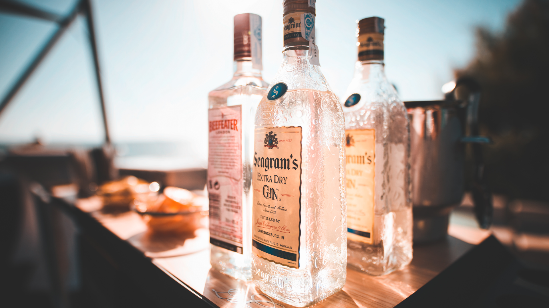 Bottles of Liquor on Patio With Lake in Background