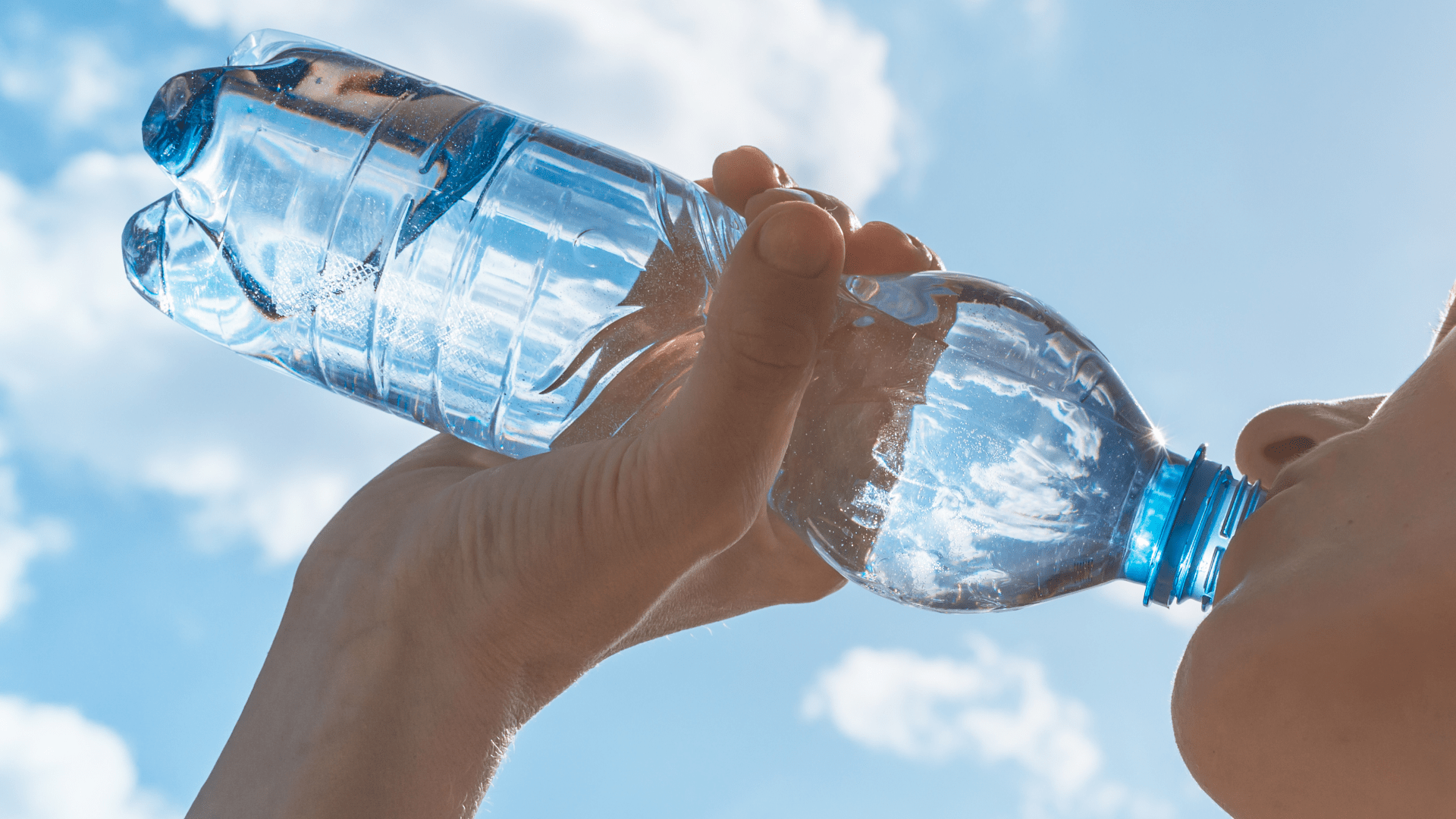 Woman Drinking Water Bottle with Sky in Background Woman Drinking Water Bottle with Sky in Background