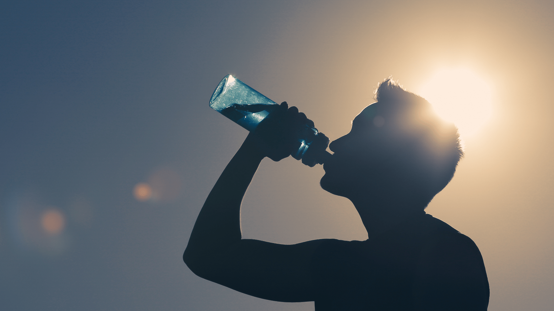 Silhouette of Man Drinking Water Bottle with Sun in Background Silhouette of Man Drinking Water Bottle with Sun in Background