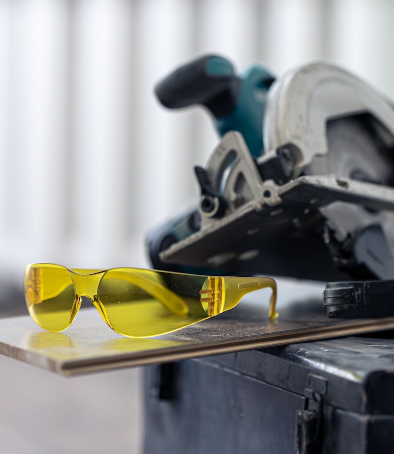 Close up of construction safety goggles and work tools. Tower Street Insurance Loss Control OSHA Safe and Sound Week