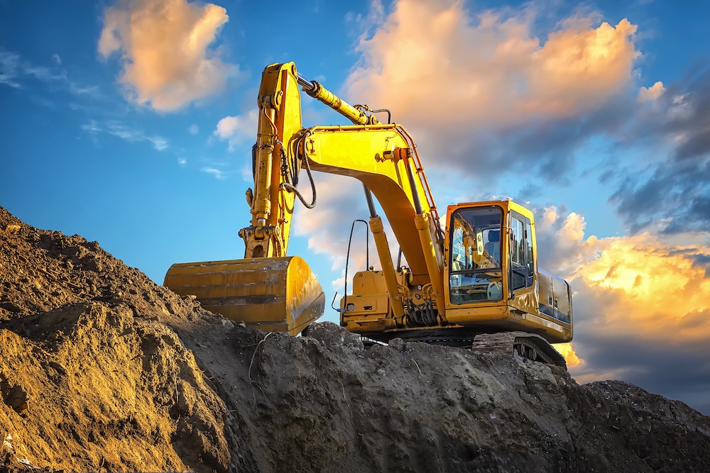 A stopping yellow excavator at an incredibly beautiful sunset Tower Street Insurance Loss Control OSHA Safe and Sound Week