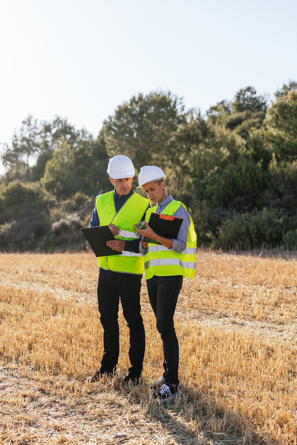 Two engineers working together outdoors in the field. Tower Street Insurance Loss Control OSHA Safe and Sound Week
