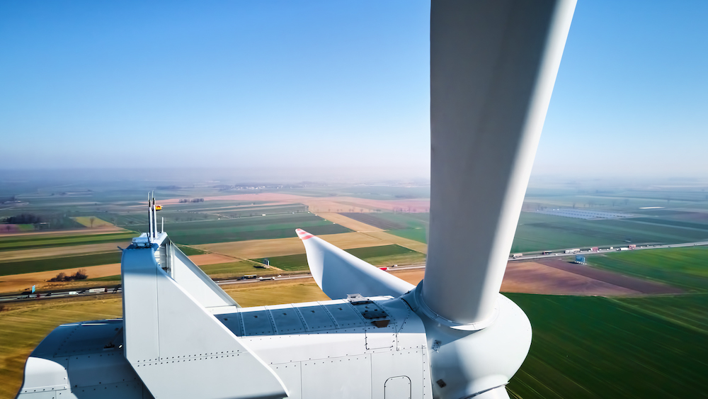 Aerial view of part of windmill turbine in countryside, Green energy Tower Street Insurance Assisted Living Ambulance Services